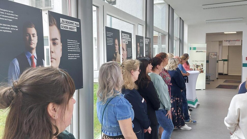 Bild zeigt eine Gruppe von Menschen bei einer Ausstellung