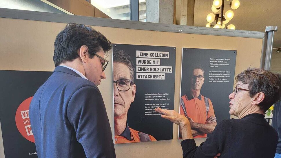 Mann und Frau vor Ausstellungsplakaten