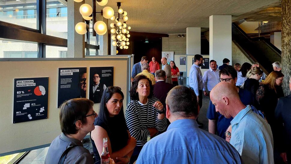 Viele Personen vor Ausstellungsplakaten