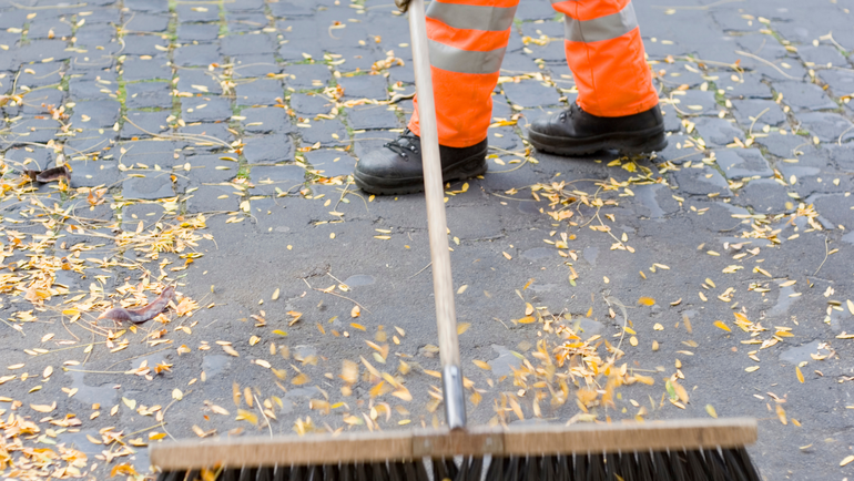 Mitarbeitende der Berliner Stadtreinigung säubern die Straße.