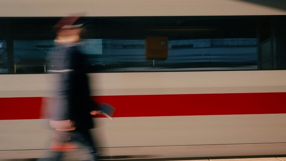 MItarbeiter*in der Bahn geht an ICE entlang.