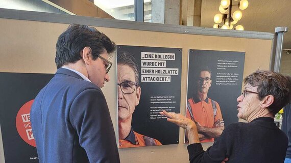 Mann und Frau vor Ausstellungsplakaten